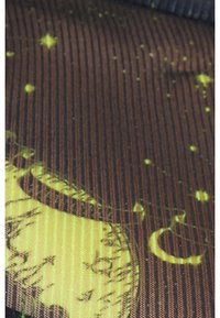 Mustapohjainen ja keltainen kangas uritetulla pinnalla, jossa on taivaankappaleiden kuvioita tähdistä ja kuuista ruskealla taustalla.