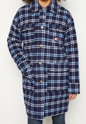 Cappotto a quadri blu navy e azzurro chiaro con due tasche frontali, chiusura con bottoni e colletto. Realizzato in un tessuto morbido e testurizzato con una vestibilità comoda.