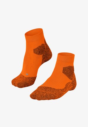 Ein Paar orange Knöchelsocken mit schwarzem, strukturiertem Fersen-, Zehen- und Sohlebereich, die für sportliche Zwecke konzipiert wurden.
