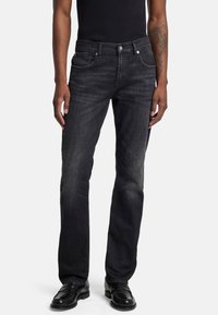 Zwarte denim jeans met een straight-leg ontwerp, vijf zakken stijl en contrasterende stiksels. Gekocht met zwarte schoenen en een aansluitend zwart top.