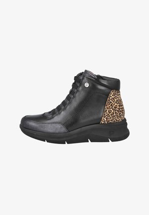 Zapatilla alta de cuero negro con parche en el talón de estampado de leopardo, cordones negros y suela gruesa negra, vista desde el lado exterior.