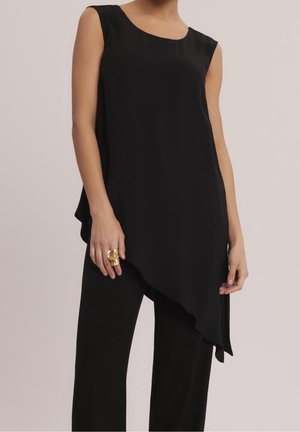 Schwarzes ärmelloses Oberteil mit asymmetrischem Saum aus glattem Stoff. Das Design verfügt über einen Rundhalsausschnitt und fällt sanft über den Körper.