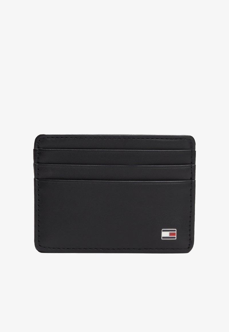 Porte-cartes en cuir noir avec trois emplacements pour cartes et un petit logo rectangulaire rouge, blanc et bleu dans le coin inférieur droit.