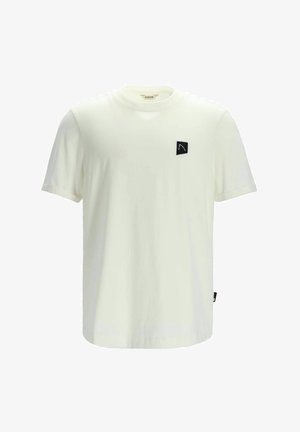 Camiseta de algodón blanca con mangas cortas, escote redondo y un parche cuadrado negro con un logo blanco en el lado izquierdo del pecho.