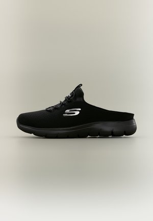 Basket noir Skechers sans lacets, avec une tige en mesh, une semelle épaisse et amortissante et un logo S argenté, présenté de profil.