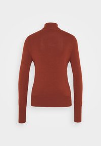 Maglione a collo alto color ruggine realizzato in un tessuto a maglia liscia. Presenta maniche lunghe e una silhouette aderente, con un orlo a coste.