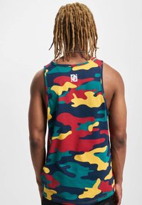 Tricou fără mâneci cu model de camuflaj multicolor, prezentând motive verzi, roșii și galbene, realizat dintr-un material moale. Detaliu cu logo pe spate.
