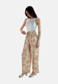 Lichte, vloeiende wijde broek in een beige en witte tropische bladerenprint, met een elastische tailleband en een relaxte pasvorm.