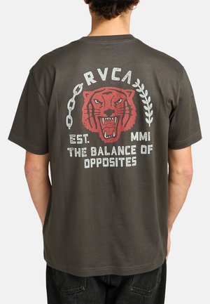 Donkergrijze katoenen t-shirt met een grafisch ontwerp van een rode tijgerkop, kettingen en de tekst "RVCA EST. MMI DE BALANS VAN TEGENSPOEDEN."