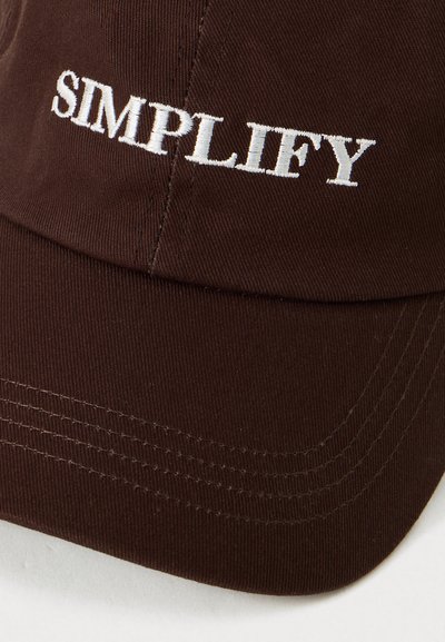 Donkerbruine stoffen pet met het witte geborduurde woord "SIMPLIFY" op de voorkant, met gedetailleerd stiksel op de rand.