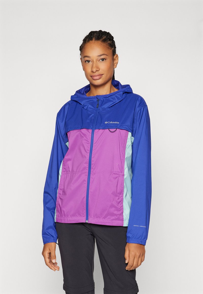 Kleurrijke, weersbestendige jas met een blauwe capuchon, paarse voorkant en lichtblauwe zijpanelen. Voorzien van zippered zakken en elastische manchetten.