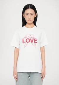 Biely bavlnený tričko s veľkým červeným potlačou "LOVE" a obrysom dvoch postáv čelom k sebe. Krátke rukávy, klasický strih.
