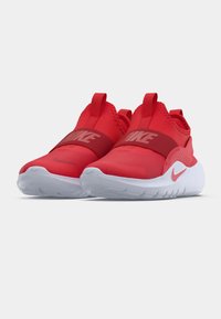 Scarpe da atletica rosse con un tessuto superiore liscio e flessibile, dotate di una fascia larga a metà piede. La suola è bianca con motivi di presa texturizzati.