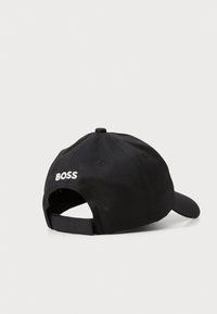 Svart baseballcap laget av vevd stoff, med buet skjerm og justerbar stropp. "BOSS"-logo brodert på baksiden.