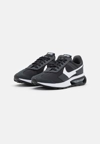 Black athletic shoes with a textured fabric upper, white Nike swoosh, padded collar, and visible air cushioning in the sole.