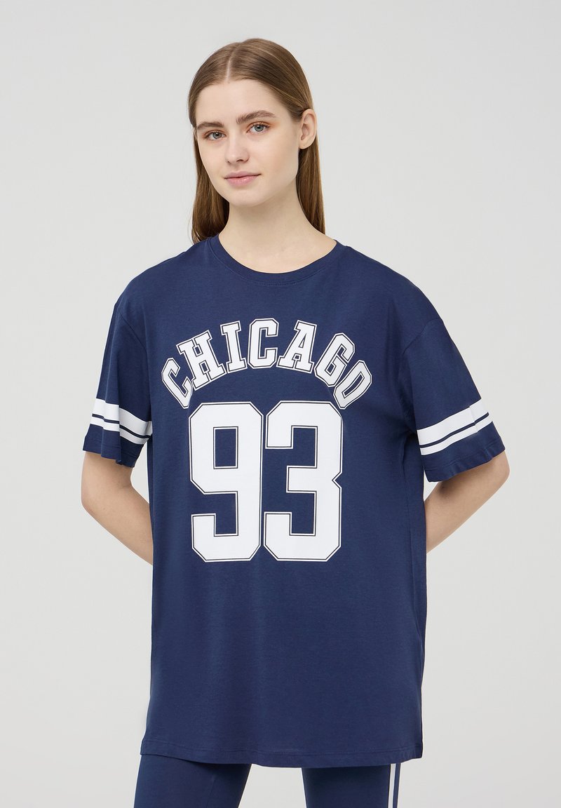 T-shirt oversized blu navy, in cotone, con la scritta "CHICAGO" e "93" in stampato bianco bold, con righe bianche sulle maniche.