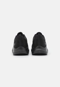 Black athletic shoes with a mesh upper, textured back, and rubber sole. Features a pull tab at the heel for easy wear.