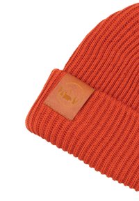 Dzianinowa pomarańczowa czapka z prążkowanym wzorem, z brązową skórzaną naszywką z wytłoczonym logo na mankiecie.