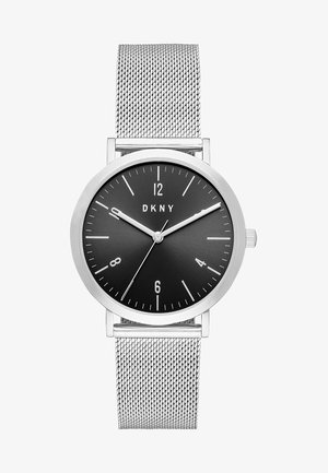 Montre-bracelet à bracelet en maille argentée avec cadran rond noir, index horaires blancs, trois aiguilles indiquant 9:09:41, et logo DKNY sous 12 heures.