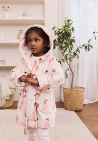 Puha rózsaszín fürdőköntös kapucnival, színes flamingó és lány mintákkal, két első zsebbel és hozzáillő övvel. Puha tapintású.