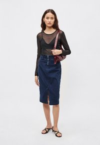 Juodas permatomas ilgarankoviai marškinėliai, tamsiai mėlynas aukštu liemeniu džinsinis sijonas su priekine skeltuke ir juodos dirželiais puoštos basutės. Bordo spalvos peties rankinė kaip akcentas.