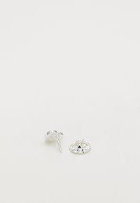 Pendientes de plata con un acabado pulido; uno presenta una forma redonda y un respaldo plano, mientras que el otro tiene un diseño decorativo.
