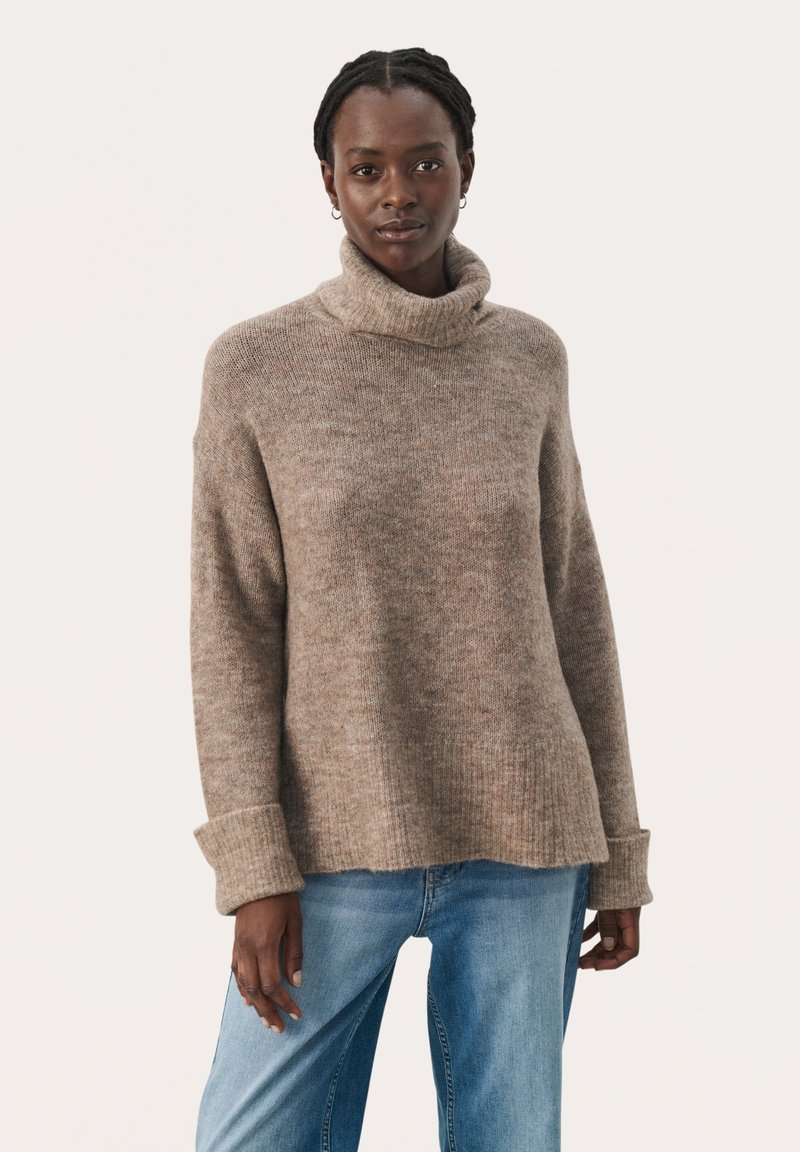 Pull à col roulé marron clair en tissu tricoté doux, présentant une coupe décontractée, des poignets côtelés et une subtile texture chinée.