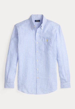 Camisa azul claro com botões, com riscas verticais brancas, mangas longas, um bolso no lado esquerdo do peito e um logótipo amarelo no bolso.