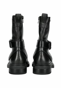 Botas de tobillo de cuero negro con un acabado texturizado, cierre de cremallera, correa ajustable y una suela robusta de goma negra.
