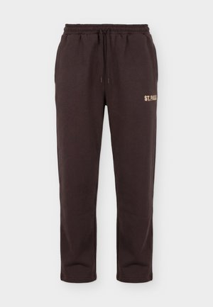 Ciemnobrązowe dresowe spodnie z elastycznym pasem, sznurkiem, bocznymi kieszeniami i nadrukiem "ST. PAULI" w beżowym kolorze na prawej udzie.