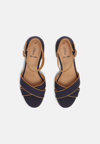 Sandali blu navy con cinturini incrociati, suola in morbida schiuma e dettagli in tan. Cinturino regolabile alla caviglia per migliorare la vestibilità e il comfort. Taglia 39.