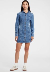 Sukienka koszulowa z denimu w jasnoniebieskim kolorze, z guzikowym zapięciem z przodu, długimi rękawami, klasycznym kołnierzem oraz kontrastującymi detalami w szwach.