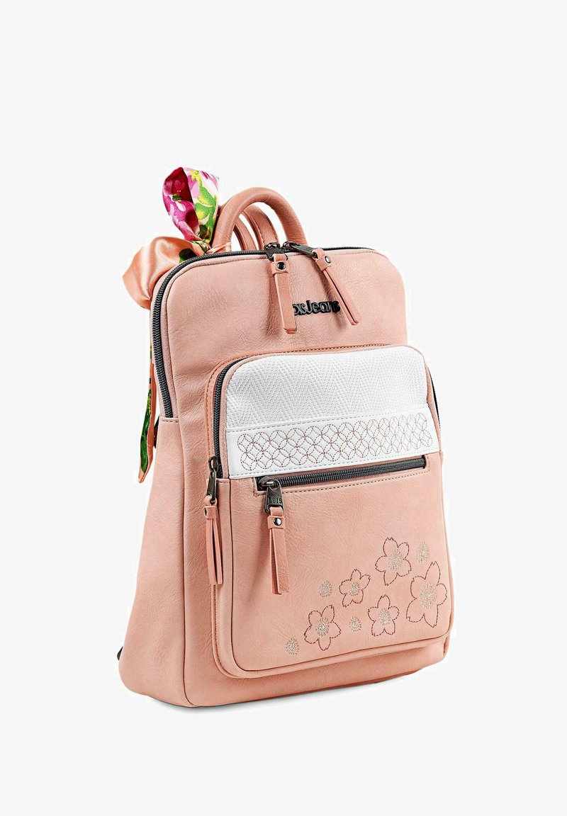 Mochila de imitación de cuero rosa con un bolsillo frontal texturizado blanco, bordado floral, cremalleras dobles y un lazo de patrón colorido adjunto.