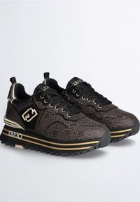 Paire de baskets noires et brunes à motifs, avec des accents dorés, des semelles épaisses rayées, des lacets noirs et le logo "LIU·JO" sur la languette et la semelle.