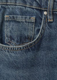 Denim plave traperice s stražnjim džepom s izvezenim obrubom, bakrenim šavovima i vidljivim metalnim zakovicama.