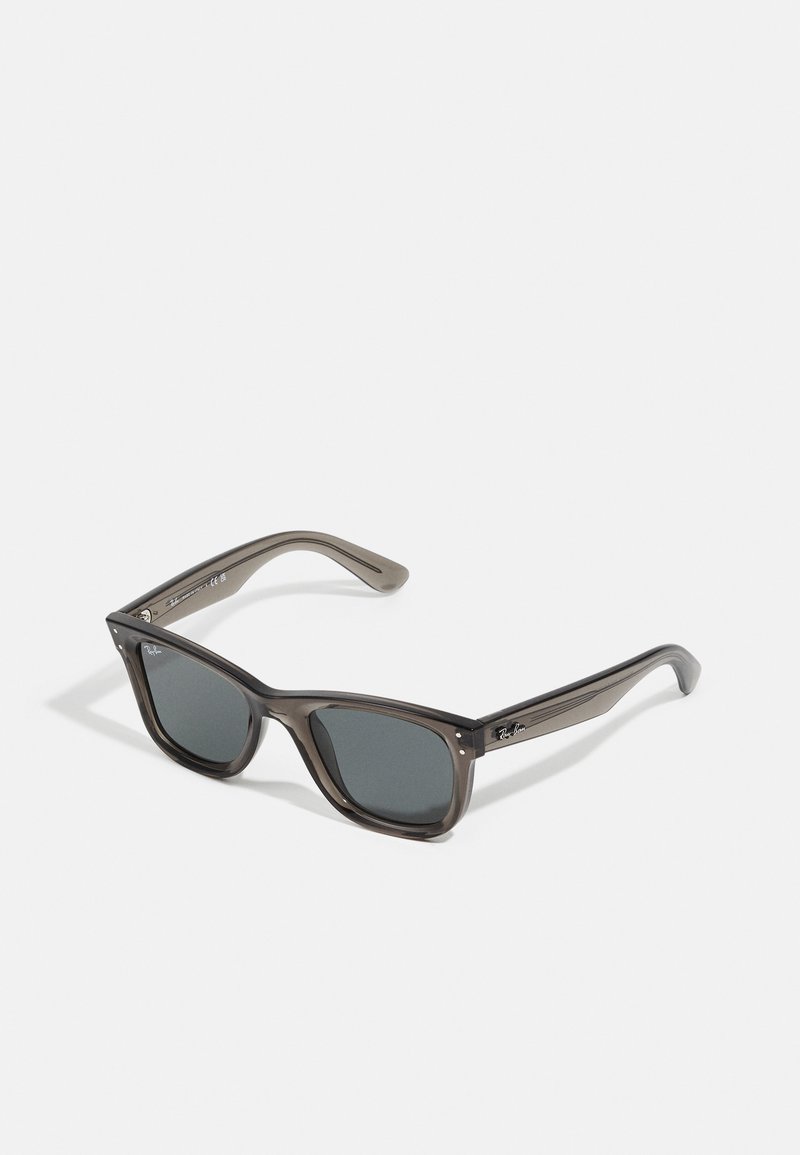 Ochelari de soare gri închis, cu o ramă rectangulară groasă din plastic translucid. Au lentile gri și detalii discrete ale mărcii pe braț.