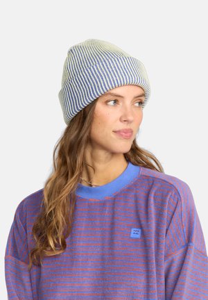 Knitted beanie in white and blue stripes; features a soft texture. Worn with a purple striped long-sleeve shirt with a blue collar.