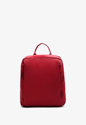 Red fabric backpack with a rectangular shape, front zipper pocket, and top handle. Smooth texture with no visible patterns or hardware.