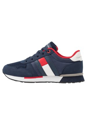 Marineblå sneaker med røde og hvide striber, rødt indvendigt for, hvid hældetalje og hvid og sort sål.