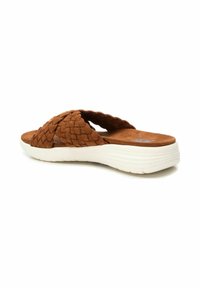 Sandalias deslizantes trenzadas marrones con parte superior de ante suave y suela blanca ligera. Cuenta con un diseño de dos tiras y una plantilla texturizada.