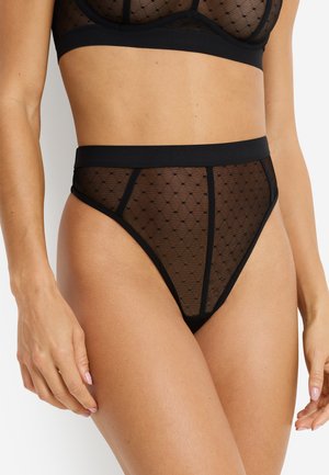 Czarny biustonosz typu bralette z siateczki oraz wysokie stringi z kropkowanym wzorem, elastyczną taśmą i przezroczystą fakturą. Kluczowe elementy projektu to trójkątne segmenty.