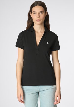 Polo shirt nera con colletto corto, pattina con bottoni e logo ricamato sul lato sinistro del petto. Materiale di cotone morbido e liscio.
