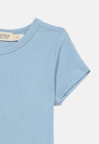 Ανοιχτό μπλε ριγωτό κοντομάνικο πουκάμισο με στρογγυλεμένο λαιμό και ορατή ραφή στην άκρη του μανικιού σε λευκό φόντο.