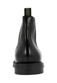 Stivali Chelsea neri in pelle con un design elegante, punta arrotondata, pannelli elastici laterali testurizzati e un linguetta verde a contrasto.