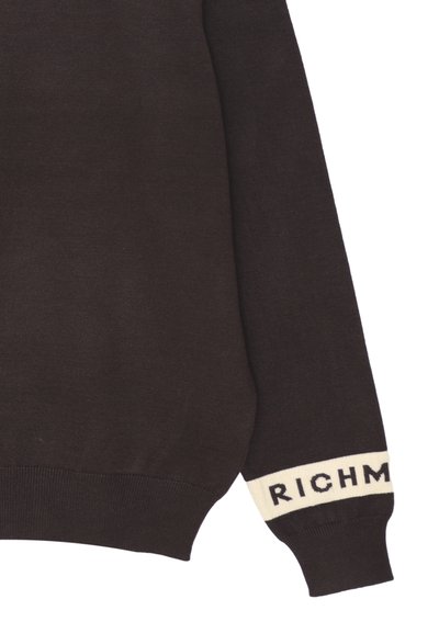 Maglione marrone con una texture a coste, dotato di una fascia bianca al polsino che mostra la parola "RICH". Design classico con scollo a giro.