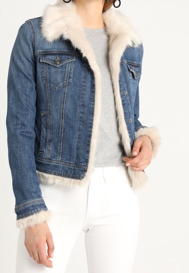 Džínová bunda se světlým kožíškem na límci a manžetách, vybavená dvěma náprsními kapsami, viditelnými švy a zkráceným střihem. Modrá barva.