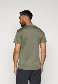 Olive rohelise värvi lühikeste varrukatega T-särk pehme, tekstureeritud kangaga ja ümarate kaelustega. Seljaosas on peen heathereritud muster.