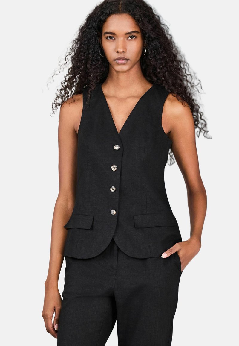 Gilet nero senza maniche con scollo a V, cinque bottoni e due tasche frontali. Realizzato in tessuto testurizzato, ha una vestibilità sagomata.