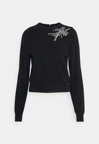 Czarny sweter z długim rękawem, okrągłym dekoltem i kryształowym zdobieniem w wzór promieni słonecznych na górnej lewej części klatki piersiowej.