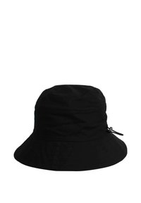 Svart bucket hat i mjukt tyg med rund kulle och bred, nedåtvinklad brätte. Har en justerbar dragsko på sidan.